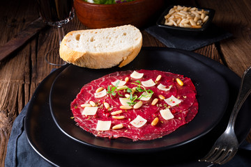 Carpaccio of beef with pine nuts, colorful pepper and Parmesan cheese