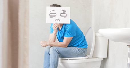 man with constipation on toilet