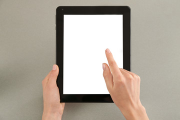 Young woman using tablet computer on grey background