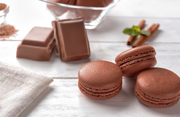 Delicious chocolate macarons on table