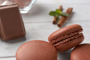 Delicious chocolate macarons on table