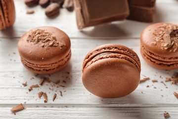 Delicious chocolate macarons on wooden background