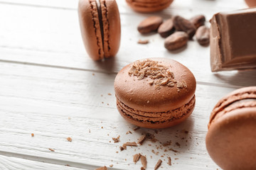 Delicious chocolate macarons on wooden background