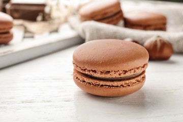 Delicious chocolate macaron on table