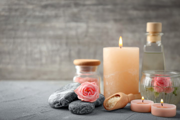 Spa composition with candles and flowers on grey table