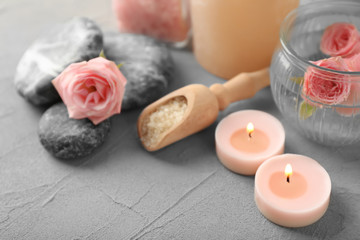 Fototapeta na wymiar Spa composition with candles and flowers on grey background