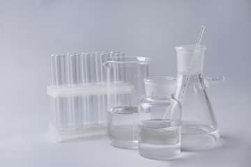 Different laboratory glassware on grey background