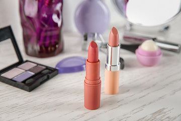 Lipsticks on white wooden table