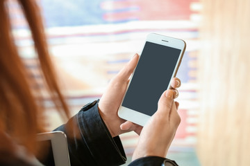 Woman using mobile phone on blurred background