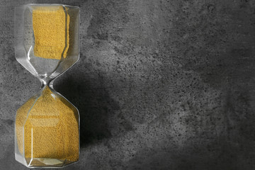 Hourglass on grey textured background. Time management concept