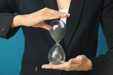 Woman holding hourglass, closeup. Time management concept