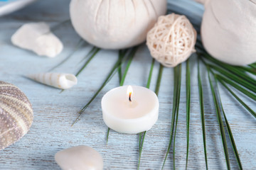 Fototapeta na wymiar Beautiful spa composition with sea shells and burning candle on wooden background