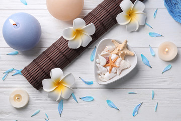 Fototapeta na wymiar Flat lay composition with shells, flowers and spa accessories on wooden background