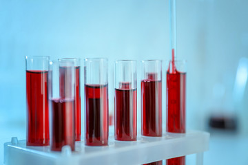 Dripping blood samples into test tubes, closeup
