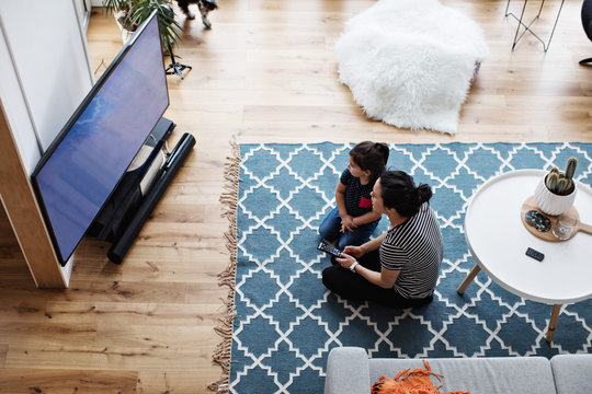 Mother and daughter watching tv at home