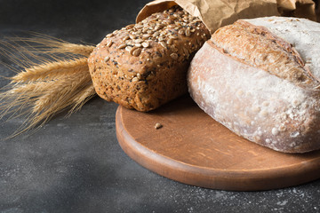 Homemade rye bread with sunflower seeds on dark board. Close up.