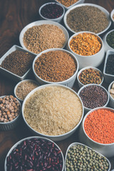 Uncooked pulses,grains and seeds in White bowls over wooden background. selective focus