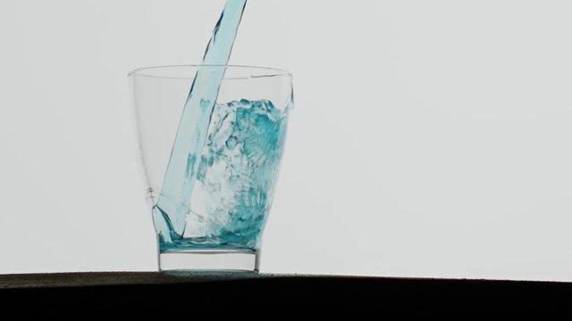 Blue drink poured in glass,200 fps slowed splash.