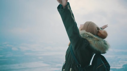 Woman with backpack hiking on mountain under blue sky with sunlight at sunny winter day, travel vacation, landscape mountains background.