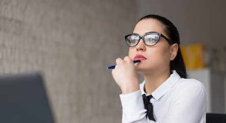 Young smart caucasian woman thinking in office portrait