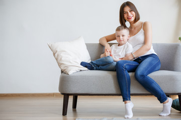 Picture of happy mother with son sitting on sofa