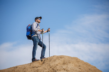 Picture of tourist man with sticks for walking on hill