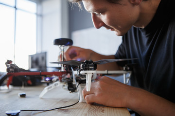 Picture of engineer fixing square copter at table