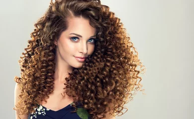 Photo sur Aluminium Salon de coiffure Brunette  girl with long  and   shiny curly  hair .  Beautiful  model woman  with wavy hairstyle  