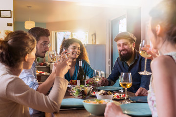 Mixed group of friends having fun while sharing a meal 
