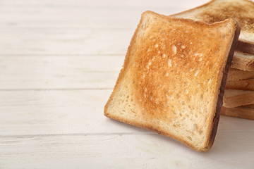Tasty toasted bread on table