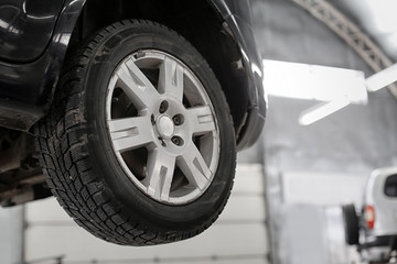 Car on lift at service center, closeup