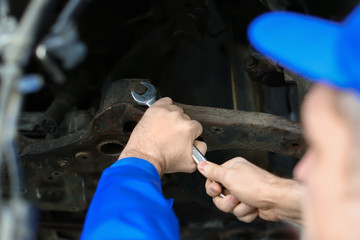 Fototapeta na wymiar Male mechanic fixing car in service center
