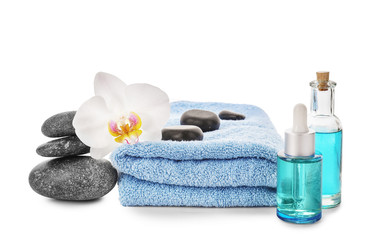 Fototapeta na wymiar Beautiful spa composition with towel, bottles of essential oil and stones on white