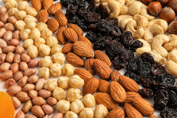 Different nuts and raisins as background, closeup
