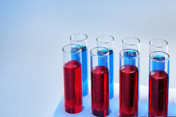 Test tubes with different liquids on color background