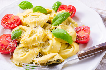 ravioli with spinach filling, grated cheese and cocktail tomatoes