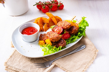 Meatballs skewers of tomato, paprika and baked potato quarters