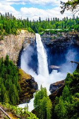 Fototapeta premium Large snow melt in the Cariboo Mountains creates spectacular water flow of Helmcken Falls on the Murtle River in Wells Gray Provincial Park near the town of Clearwater, British Columbia, Canada