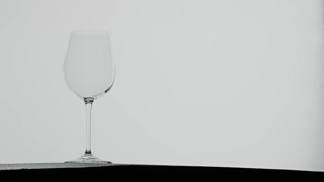 Red vine poured into a vine glass, dramatic slow motion splash