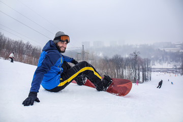 Male snowboarder on slope at winter resort