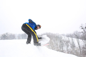Male snowboarder on slope at winter resort