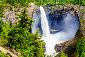 Fototapeta premium Large snow melt in the Cariboo Mountains creates spectacular water flow of Helmcken Falls on the Murtle River in Wells Gray Provincial Park near the town of Clearwater, British Columbia, Canada