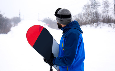 Male snowboarder on slope at winter resort