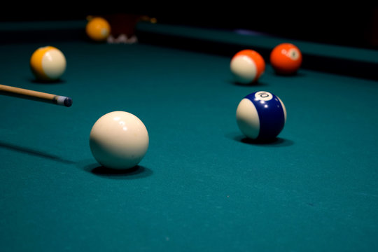 colored balls of the American pool and cue on the billiard table