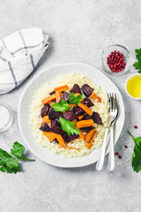 Couscous roasted root vegetables on concrete background. Top view, space for text.