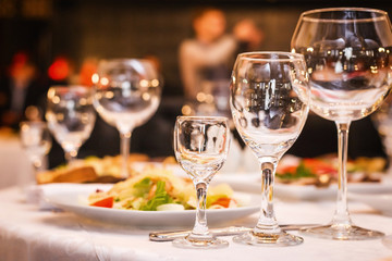 fancy wedding goblets glasses laying on the table with foods at the wedding banquet. concept of wedding decorum