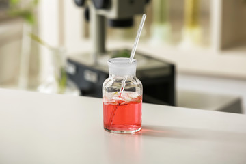 Flask with petals on table in laboratory