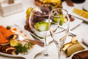 Two fancy wedding goblets glasses laying on the table with foods at the wedding banquet