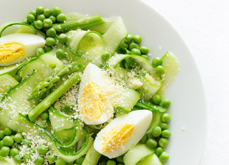 fresh green vegetables salad with egg and grated cheese dressed with oil and white vinegar