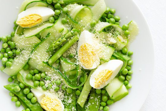 peas, asparagus, cucumber, pea pods, and egg salad dressed with oil and white vinegar and sprinkled with cheese